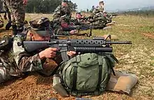 A U.S. Marine takes aim with an M16A2 fitted with the M203 40&nbsp;mm grenade launcher