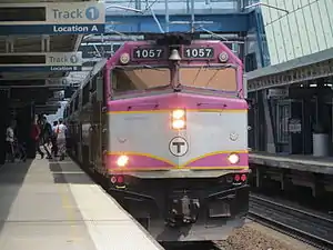 A diesel locomotive with a passenger train at a station