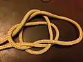 8-3-The resulting loop is folded under and the slip side of the Overhand knot pulled through it