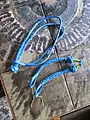 Two with [diamond knot] head, and buried eye with openinig string, one with ends-buried-button-knot and eye adjustable by crossing sides.