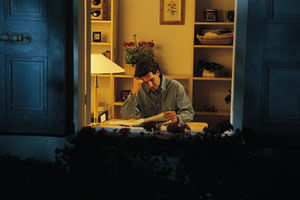 man looking over his bills in his den