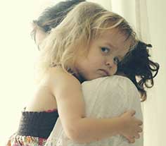 Toddler girl being held by her mother