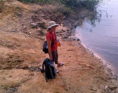 Kim had to walk several hours and canoe across the St. Paul River after an Ebola outbreak investigation. Here, she is waiting to be paddled across by a ferry captain named