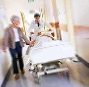Patient in hospital bed with doctor and family