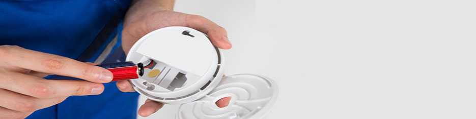 Person inspecting a Carbon Monoxide detector