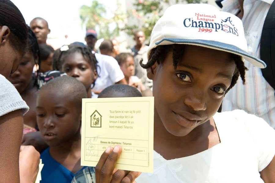 A young girl awaits a vaccine during a vaccination program at the Adventist University Camp in Port au Prince, home to 14,000 displaced people. The CDC provided rapid test kits to doctors at the site for testing malaria patients, which are being seen in increasing numbers as the rains begin to fall. © David Snyder/CDC Foundation