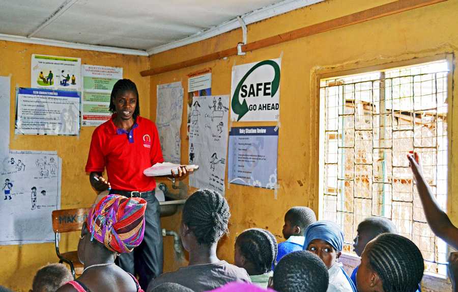 A staff from LVCT Health, a CDC Kenya partner, provides evidence-based health education and HIV prevention classes to young people in Korogocho.