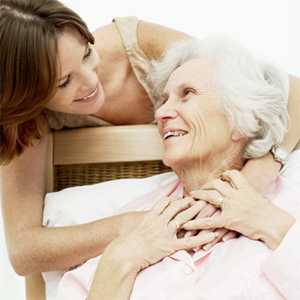 Photo: Young woman embracing an elderly woman