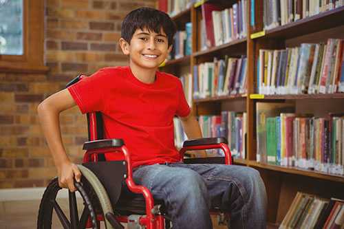Un niño en una silla de ruedas en la biblioteca