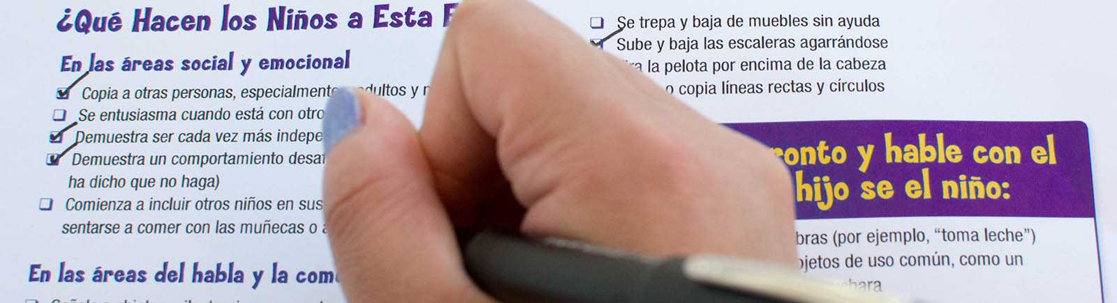 Una mujer completa una lista de un niño de dos años de edad.