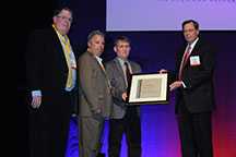 Mark Somers, Warren Gross, and Tom Parks of Lockheed Martin accept the award from Jeff Kohler of OMSHR. Mark Somers, Warren Gross, and Tom Parks of Lockheed Martin accept the award from Jeff Kohler of OMSHR.