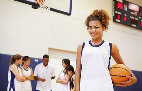 Joven sonriente en juego de baloncesto.