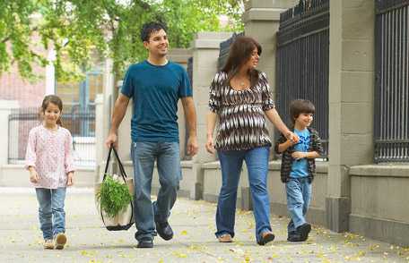 Familia camina junta en la vereda.